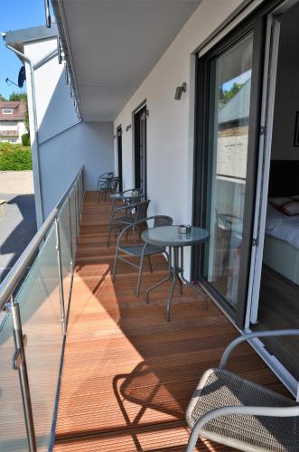 a balcony with tables and chairs on a building at Gästehaus Am Hochsimmer in Ettringen