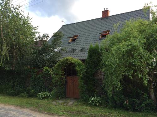 a house with a wooden door and ivy at Domek nieopodal rzeki Bug in Klepaczew