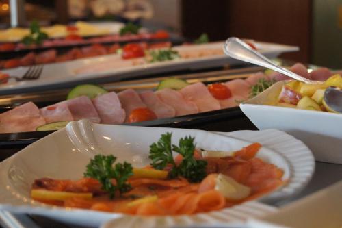 een buffet van verschillende soorten vlees en groenten bij Brenner Hotel in Bielefeld