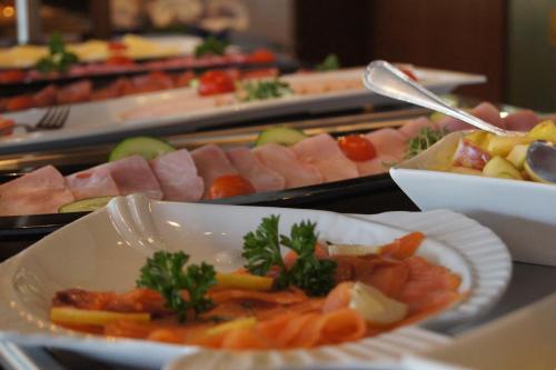 un buffet de différents types de viandes et de légumes dans l'établissement Brenner Hotel, à Bielefeld