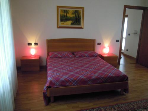 a bedroom with a bed and two lamps on two tables at B&B Emma in Torreano