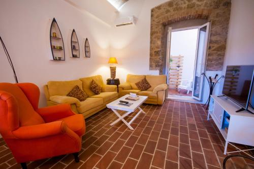 a living room with two couches and a tv at Casa do Poço in Olhão