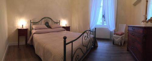 a bedroom with a bed and a dresser and window at Residenza d'Aste in Albenga