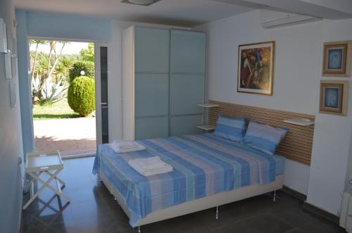 a bedroom with a bed and a sliding glass door at Olivos Villa Sani in Sani Beach