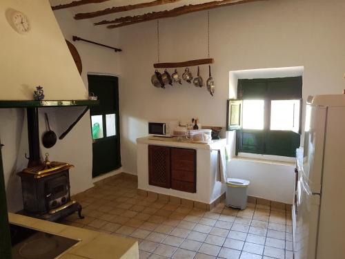 a kitchen with a stove and a refrigerator at Cortijo Romero in Venta de Micena