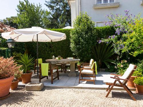 een patio met een tafel en stoelen en een parasol bij Charming Antas House in Porto