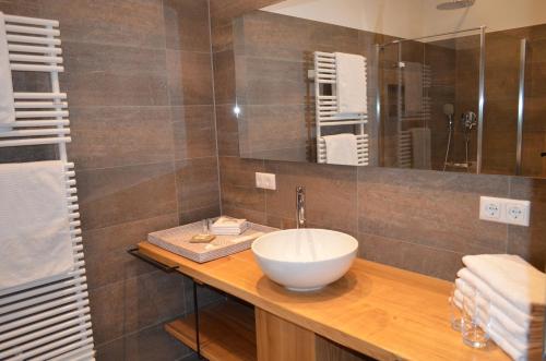 La salle de bains est pourvue d'un lavabo blanc sur un comptoir en bois. dans l'établissement Alte Posthalterei Zorneding, à Zorneding