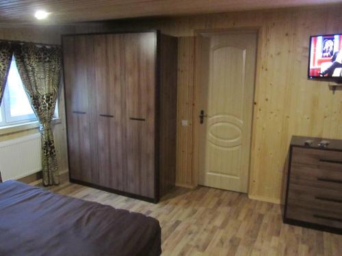 a bedroom with a door and a tv and a bed at Hotel Restaurant Vizit in Truskavets