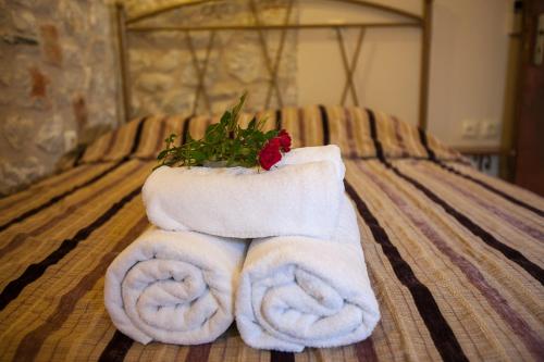 a pair of towels with a flower on a bed at Anigraia in Paralion astros