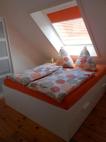 Bett in einem Zimmer mit Fenster in der Unterkunft Muschel in Werdum