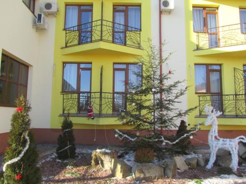 a yellow building with a christmas tree and a giraffe at Hotel Restaurant Vizit in Truskavets