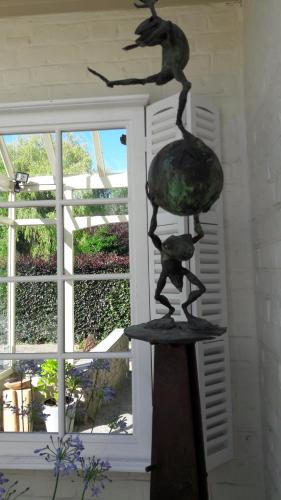 a statue of two birds on a surfboard in front of a window at Hotel Martinique in Nieuwpoort