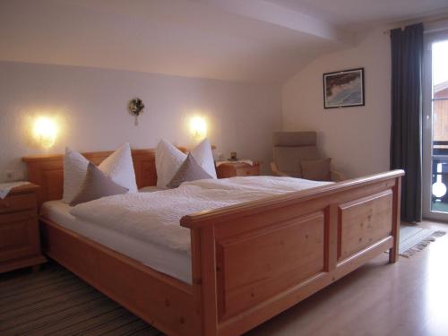 a bedroom with a large bed with white sheets and pillows at Gästehaus Dornach in Oberstdorf