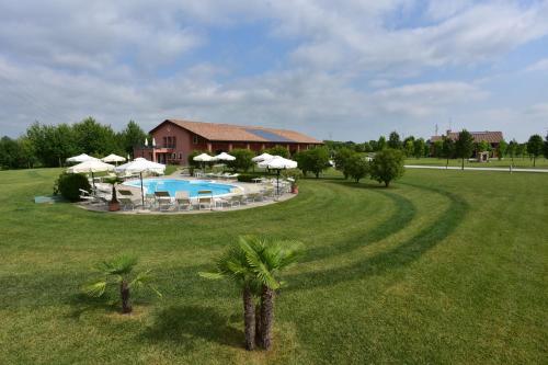 a house with a pool and umbrellas in a field at Tenuta Monterosso in Feriole