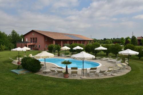 a pool with chairs and umbrellas and a building at Tenuta Monterosso in Feriole