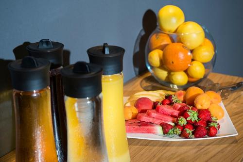 a plate of fruit and two bottles of juice at Hotel Sana in Sarajevo