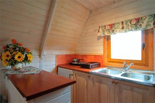 a kitchen with a sink and a vase of flowers at Bajeczne domki in Ustka