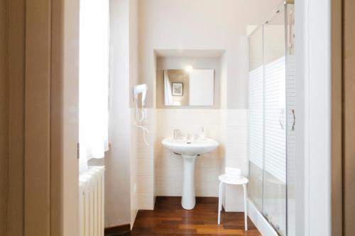 a white bathroom with a sink and a mirror at Residenza Ognissanti in Florence