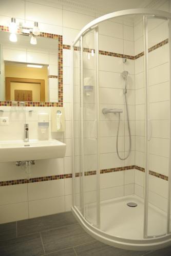 y baño con ducha y lavamanos. en Hotel Gasthof Kamml en Wals