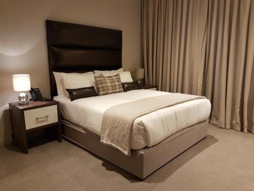 a bedroom with a large bed with a black headboard at Zimbali Suites 304 in Ballito