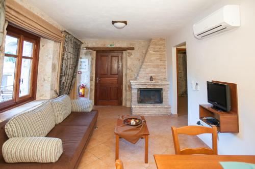 a living room with a couch and a fireplace at Anigraia in Paralion astros