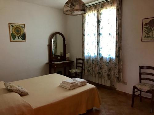 カパルビオにあるLa Fontanella del Giardinoのベッドルーム1室(ベッド1台、鏡、窓付)