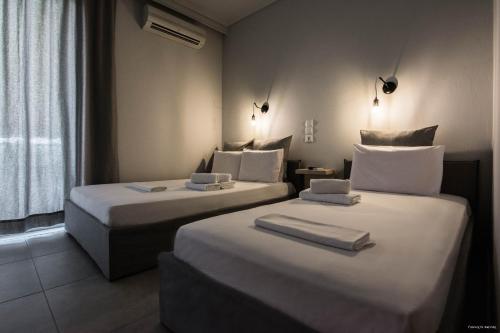 2 łóżka w pokoju hotelowym z ręcznikami w obiekcie Kochili Apartments w mieście Neos Pirgos