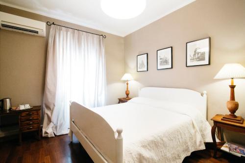 - une chambre avec un lit blanc et une fenêtre dans l'établissement Residenza Ognissanti, à Florence