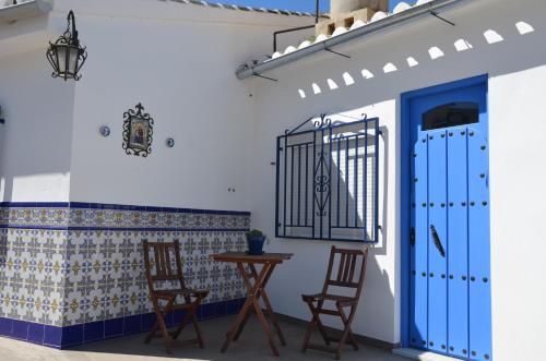 Habitación con 2 sillas y puerta azul en Casa Rural - Santo Domingo Rural, en Archidona