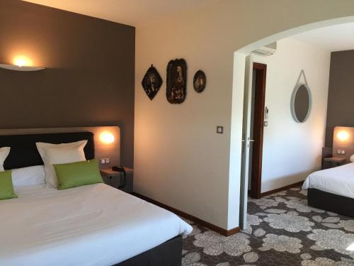 a hotel room with two beds and two mirrors at Hôtel Restaurant Vaillant proche Europapark Rulantica in Sélestat