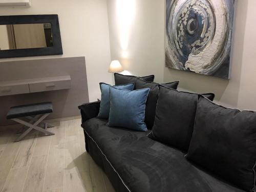 a black couch with blue pillows in a living room at Deluxe Dina in Skala Potamias