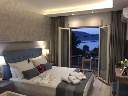 a bedroom with a large bed and a balcony at Deluxe Dina in Skala Potamias