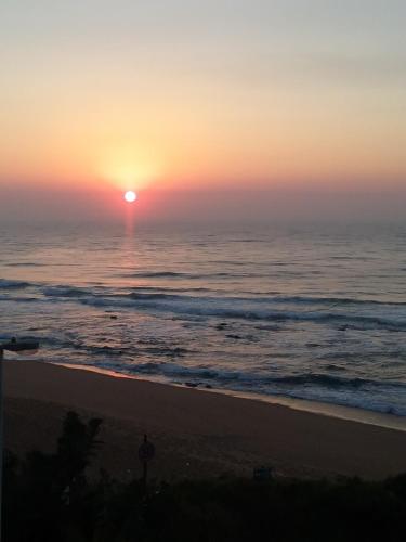 a sunset over the ocean with a beach at Greenfire Umdloti Bed & Breakfast in Umdloti