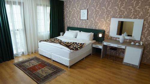 a bedroom with a bed and a table with a mirror at Khan Saray in As Sulaymānīyah
