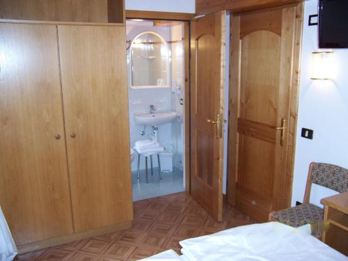 La salle de bains est pourvue d'un lavabo, d'un miroir et de toilettes. dans l'établissement Alpen Hotel Rabbi, à Rabbi