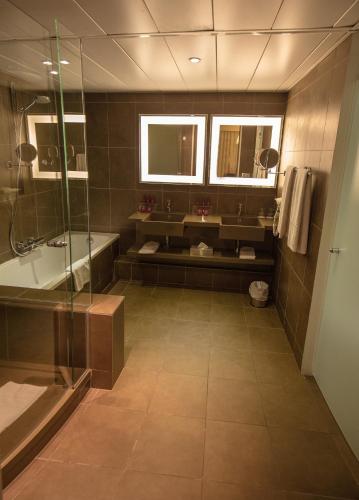 a bathroom with a shower and a sink and a tub at Accra City Hotel in Accra