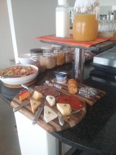 a table topped with lots of cheese and other foods at Greenfire Umdloti Bed & Breakfast in Umdloti