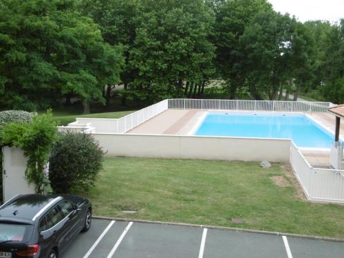 um carro estacionado num parque de estacionamento ao lado de uma piscina em residence parc de pontaillac em Vaux-sur-Mer