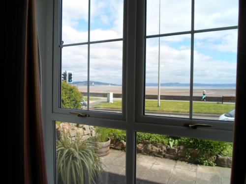 ein offenes Fenster mit Blick auf den Strand in der Unterkunft Tides Reach Guest House in The Mumbles