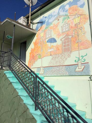 a mural on the side of a building with stairs at Guest House on Kostava 23 in K'obulet'i
