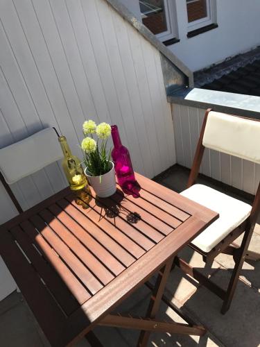 a wooden table with two bottles and a potted plant at Hotel Langhans in Abstatt