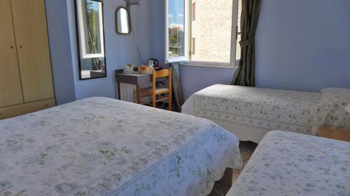a room with two beds and two windows at Bed and Breakfast Gioiello in Celle Ligure