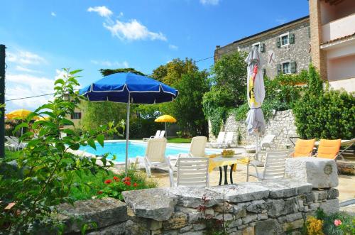 a patio with a table and chairs and an umbrella at Villa Visnjan Residence 2 in Višnjan