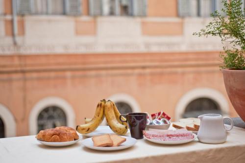 een tafel met borden met voedsel en bananen erop bij History Suite in Rome