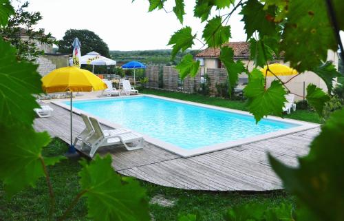a swimming pool with two chairs and umbrellas at Villa Visnjan Residence 2 in Višnjan