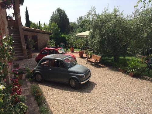 a small green car parked in a gravel driveway at Podere Il Pero in Siena