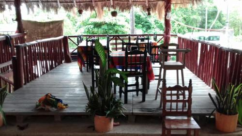 a restaurant with a table and chairs on a wooden deck at Hotel LOL-HA in Cobá