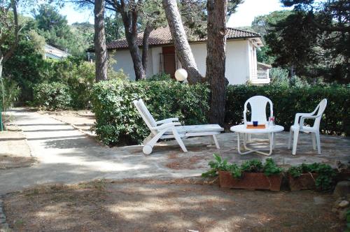 dos sillas y una mesa frente a una casa en Appartamenti Portiglioni-Belvedere, en Puntone di Scarlino