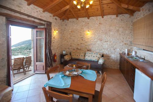 a kitchen and dining room with a table and a couch at Anigraia in Paralion astros