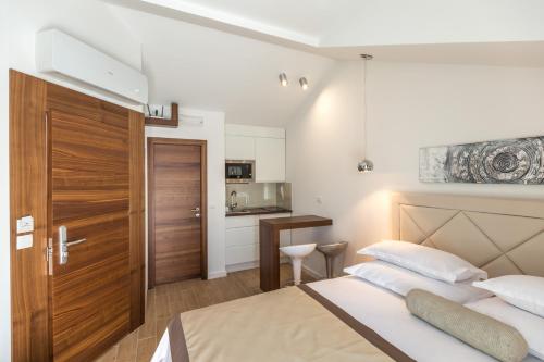a bedroom with a large bed and a kitchen at Lux Apartments Petar in Baška Voda